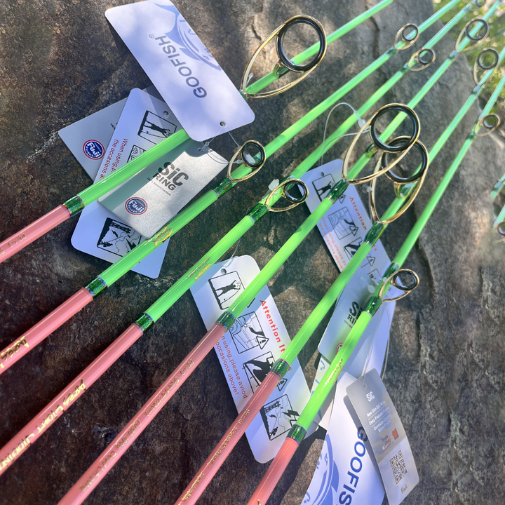 Gold-finish guide layouts on green GOOFISH Ares Light rods photographed on a rock