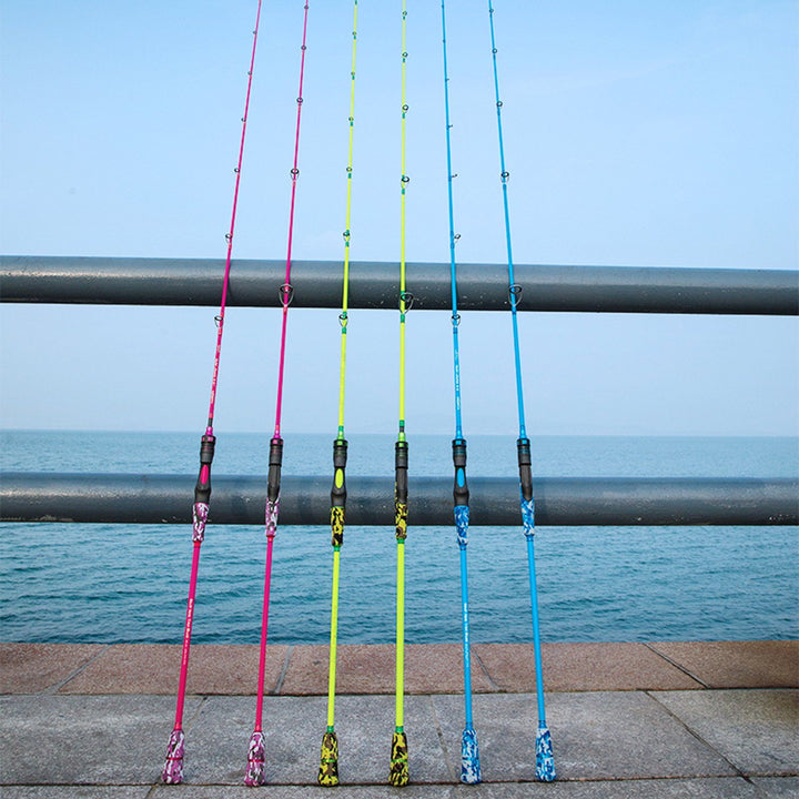 Six GOOFISH slow pitch jigging rods in pink, green and blue displayed beside a waterfront railing